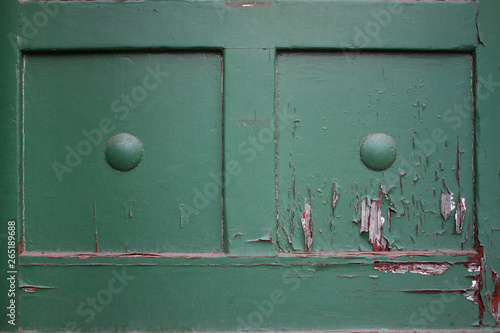 Detail of an old wooden door with worn green paint