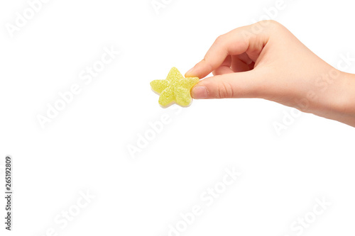 Kids hand with colored star shape candy, sugar lollipop
