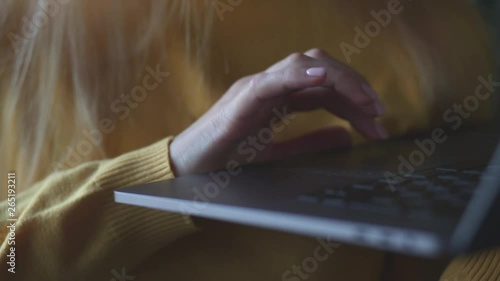 Female hands type on laptop keyboard touching touchpad with fingers close up. No face woman standing with notebook freelancing working at home writes post comments in social networks