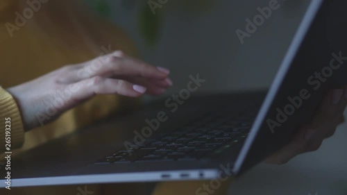 Female hands type on laptop keyboard touching touchpad with fingers close up. No face woman standing with notebook freelancing working at home writes post comments in social networks