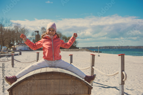 Adorable little girl playing at playground on a beach © spass
