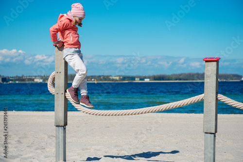 Adorable little girl playing at playground on a beach photo