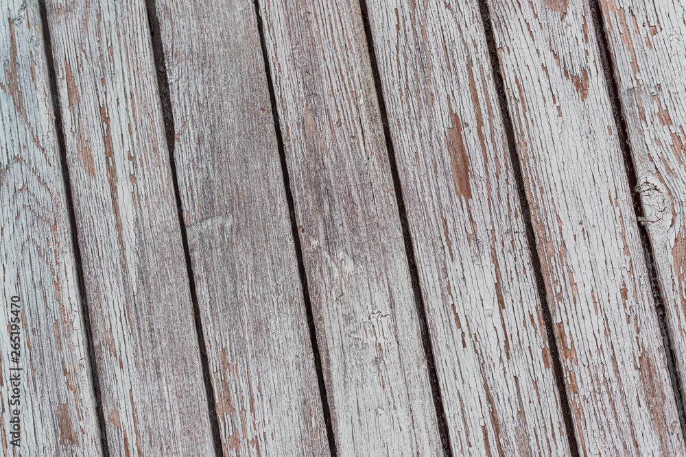 A whitewashed wooden surface worn out due to weather. Planks painted white. The texture of the wooden board. A whitewashed wooden surface worn out due to weather. Planks painted white. The texture of the wooden board.