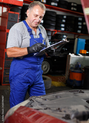 Car mechanic writing job sheet © JackF