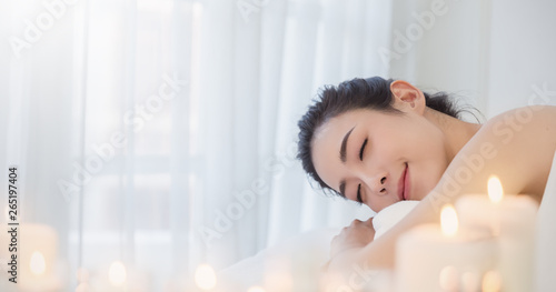 Closeup beautiful asian young  woman lying down on massage beds at Asian luxury spa and wellness center. Portrait of beauty woman relaxing with copy space, healthcare lifestyle concept banner.