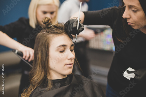 Eyebrow dyeing. The master paints eyebrows with henna to a beautiful girl, paints with a brush in the salon of a beautician-makeup artist. Brow architecture photo