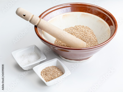 Preparation of gomashio (gomasio - sekihan seasoning ) with sesame seeds and salt in Suribachi (Japanese streak mortar). Top view. photo