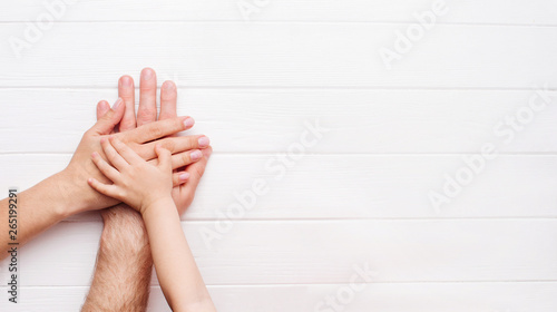 Hands of father, mother and kid on white background
