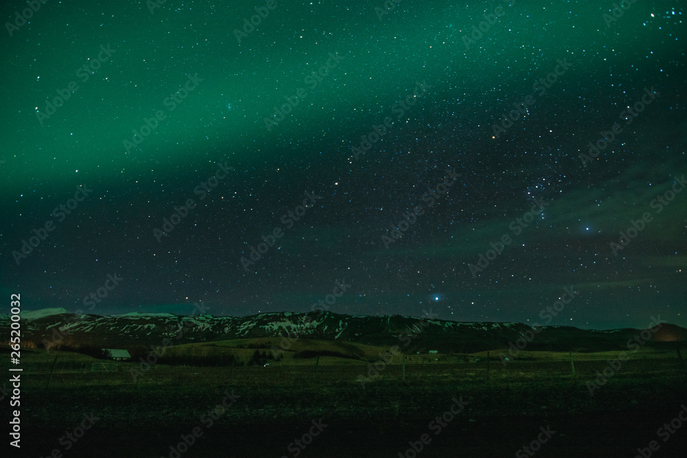 Fototapeta premium Northern Lights in cold Icelandic nights, near waterfall Seljalandsfoss