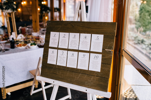 Stylish wooden restaurant decorated by greenery with black loft lamps. Wedding reception. Banquet. Decor