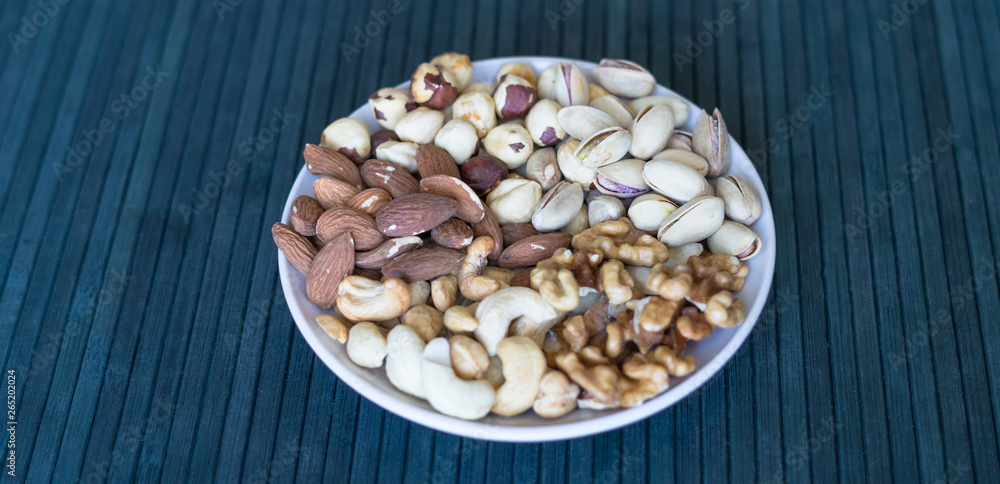 Healthy food. Nuts mix assortment on stone texture top view. Collection of different legumes for background image close up nuts, pistachios, almond, cashew nuts, peanut, walnut. image Healthy food. Nuts mix assortment on stone texture top view. Collection of different legumes for background image close up nuts, pistachios, almond, cashew nuts, peanut, walnut. image