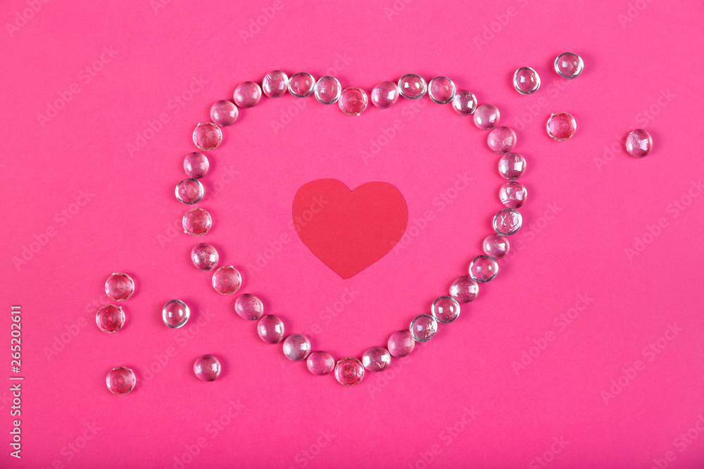 A heart lined with beads on a pink background with a heart in the middle in a frame of beads. A heart lined with beads on a pink background with a heart in the middle in a frame of beads.