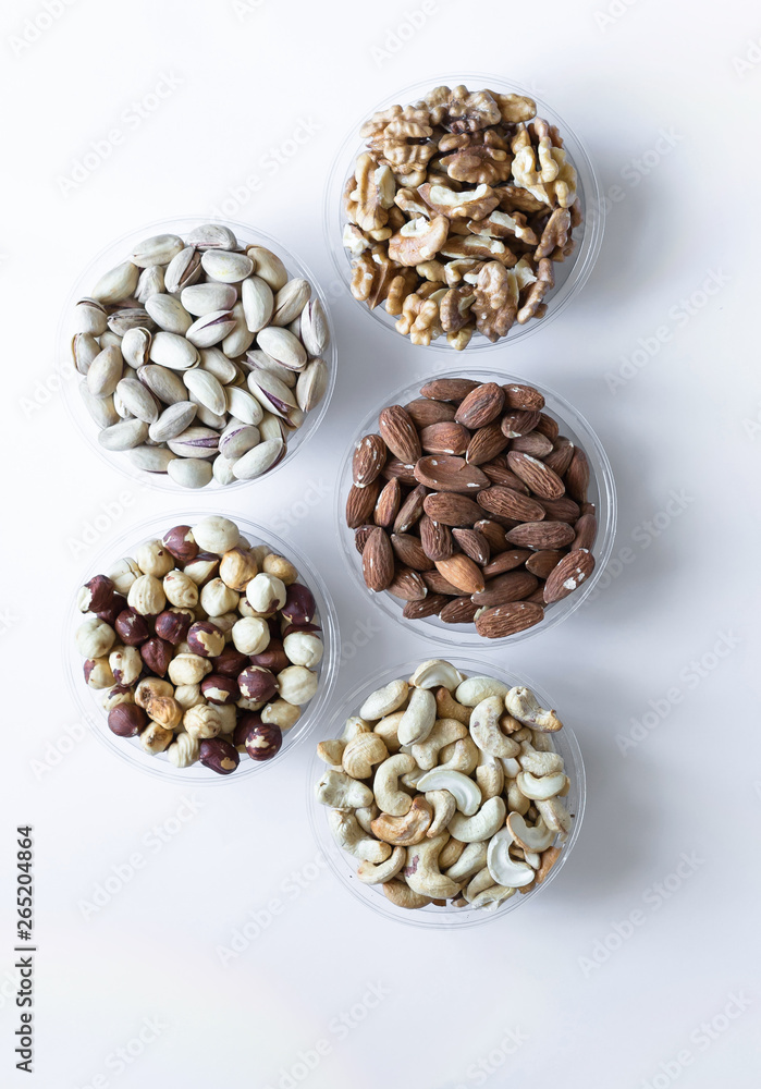 Healthy food. Nuts mix assortment on white grey table top view. Collection of different legumes for background image close up nuts, pistachios, almond, cashew nuts, peanut, walnut. image Healthy food. Nuts mix assortment on white grey table top view. Collection of different legumes for background image close up nuts, pistachios, almond, cashew nuts, peanut, walnut. image