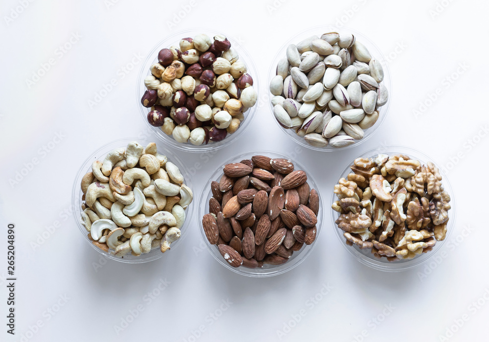 Healthy food. Nuts mix assortment on white grey table top view. Collection of different legumes for background image close up nuts, pistachios, almond, cashew nuts, peanut, walnut. image Healthy food. Nuts mix assortment on white grey table top view. Collection of different legumes for background image close up nuts, pistachios, almond, cashew nuts, peanut, walnut. image