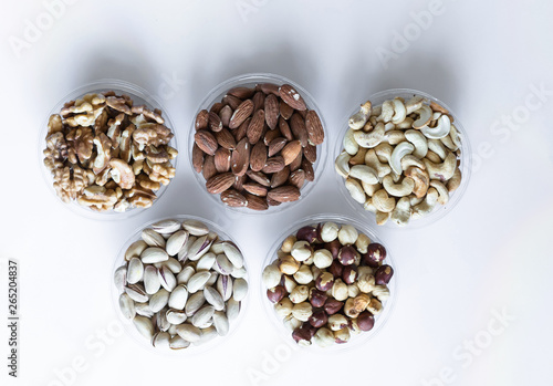 Healthy food. Nuts mix assortment on white grey table top view. Collection of different legumes for background image close up nuts, pistachios, almond, cashew nuts, peanut, walnut. image