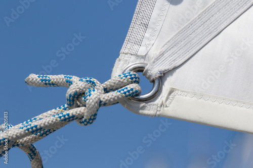 Detail of  awhit sail and knot in a rope of a recreation sailboat photo