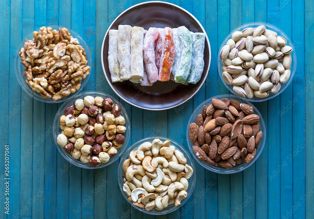 Oriental dessert halva with pistachio, almond, cashew nuts, peanut, walnut on a plate. Image. Healthy food. Nuts mix assortment. sweets, Turkish Delight. Isolated background.. Eastern delicacy Oriental dessert halva with pistachio, almond, cashew nuts, peanut, walnut on a plate. Image. Healthy food. Nuts mix assortment. sweets, Turkish Delight. Isolated background.. Eastern delicacy