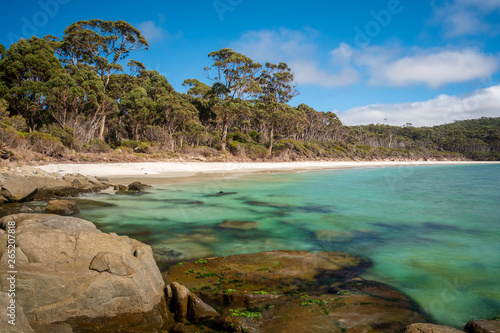 Fortescue-Bay on a sunny morning with white beach, rocks, trees and crystal clear water, Tasmania Australia