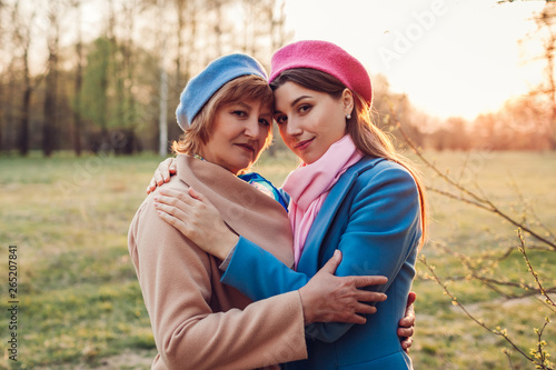 Senior mother and her adult daughter hugging in spring forest. Mother's day concept. Family values