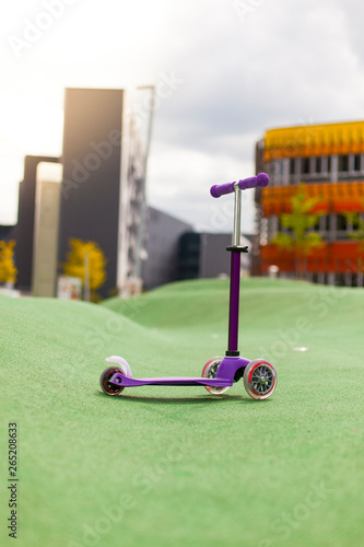 Scooter auf Spielplatz in urbaner Umgebung. Little scooter on playground in urban area.