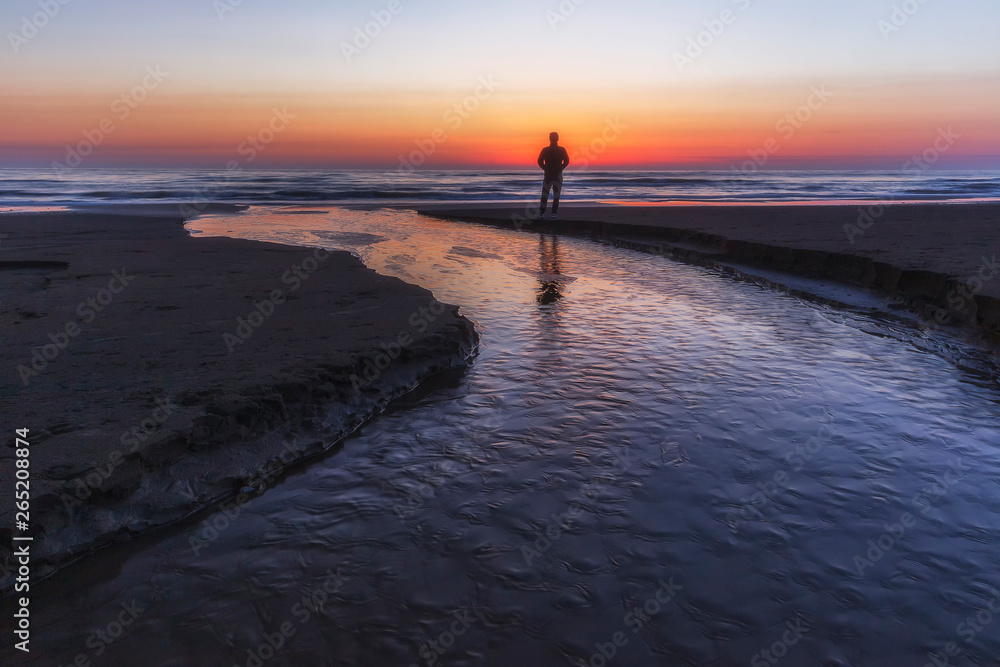 A young guy meets the sunrise by the sea A young guy meets the sunrise by the sea