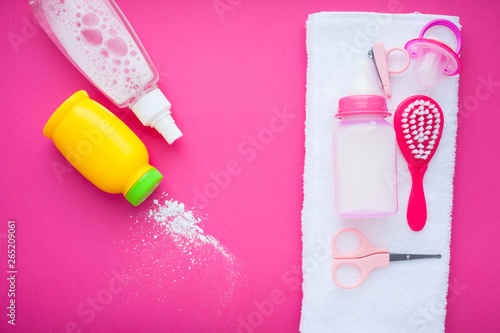 Newborn baby story. Towels and children's toys, scissors, baby bottle, nipple, hairbrush on red background
