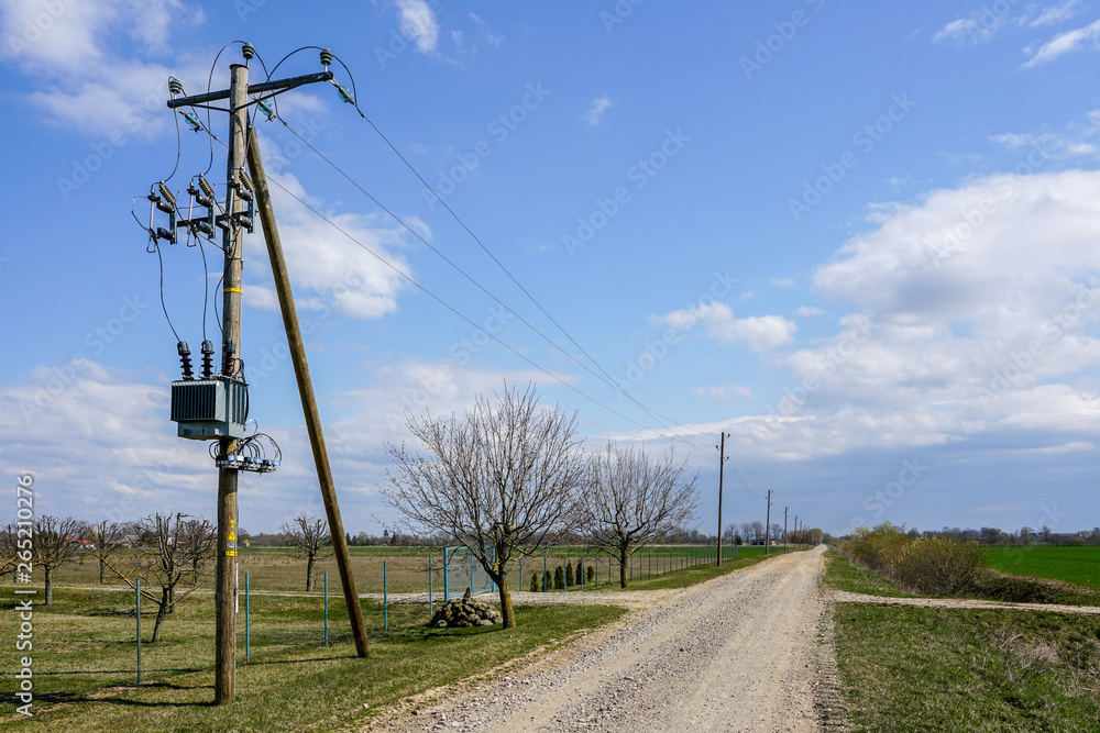 wooden power line pole with electric transformer in rural area