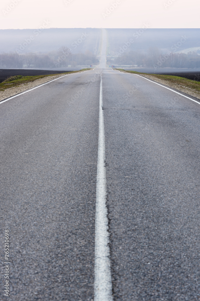 Countryside landscape. Empty straight highway with white road marking in early morning Countryside landscape. Empty straight highway with white road marking in early morning