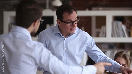 Two angry businessmen arguing having conflict confrontation at workplace photo