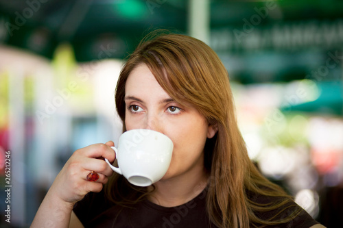 Young woman drinking hot beverage