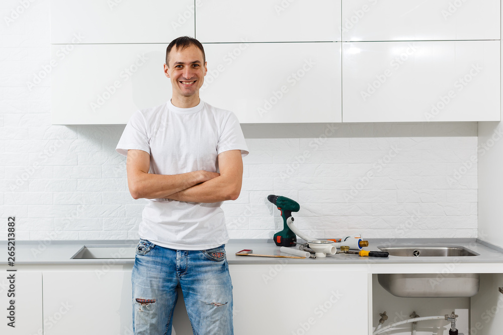 Man repairing a kitchen sink at home Man repairing a kitchen sink at home