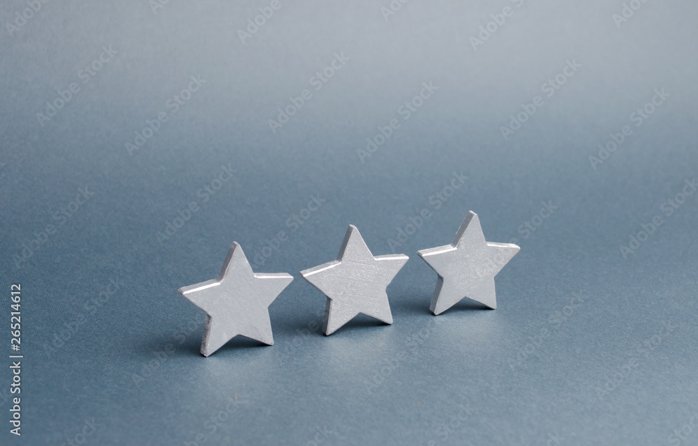 Three stars on a gray background. The concept of rating and evaluation. The rating of the hotel, restaurant, mobile application. Quality service, buyer choice. Success in business Three stars on a gray background. The concept of rating and evaluation. The rating of the hotel, restaurant, mobile application. Quality service, buyer choice. Success in business