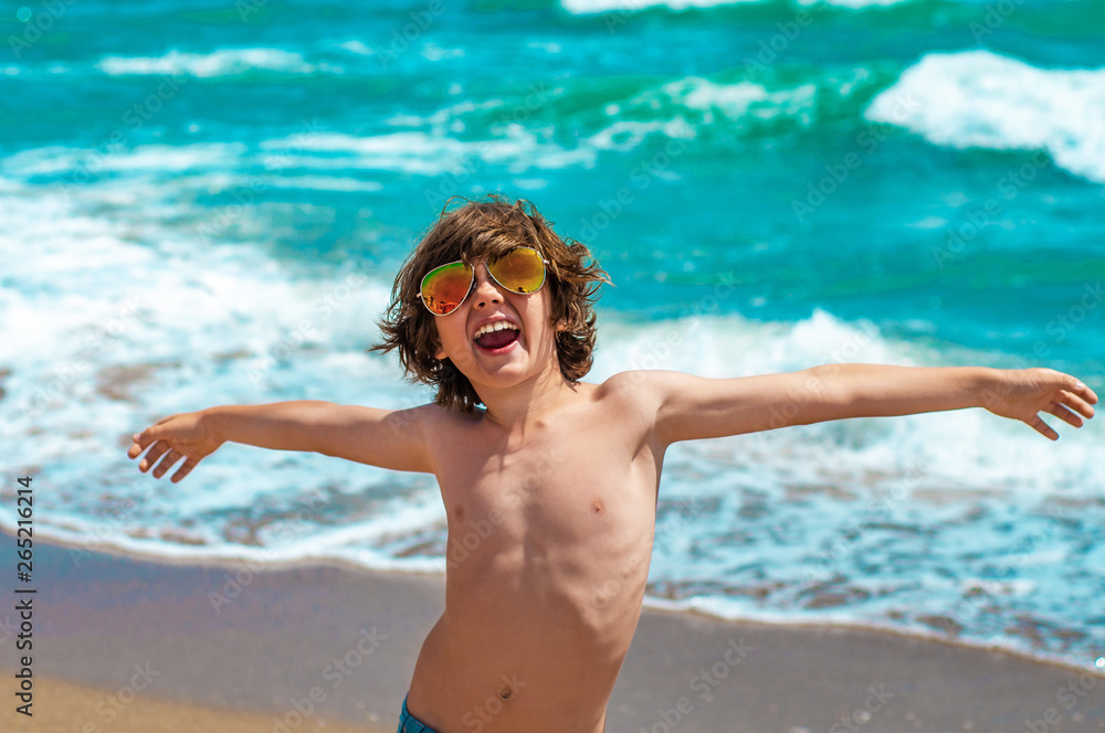 Cheerful emotional boy with arms outstretched rejoices at the se Cheerful emotional boy with arms outstretched rejoices at the se