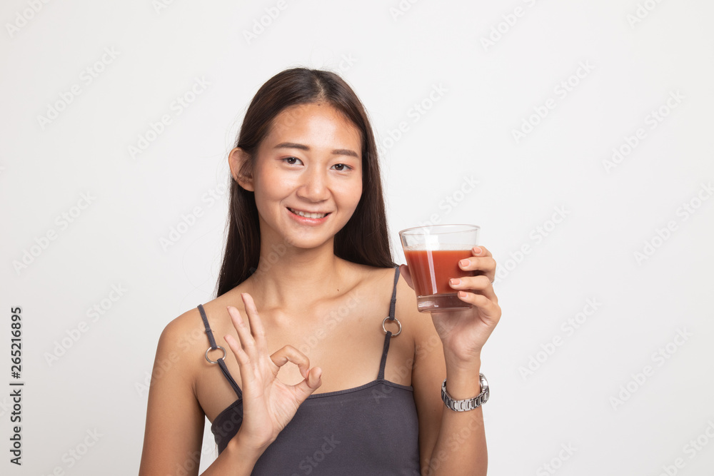Young Asian woman show OK with tomato juice. Young Asian woman show OK with tomato juice.