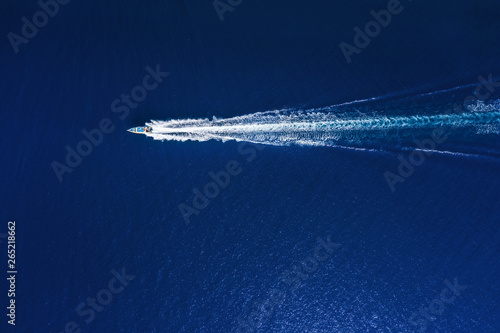 Yachts at the sea in Bali, Indonesia. Aerial view of luxury floating boat on transparent turquoise water at sunny day. Top view from drone. Seascape with motorboat in bay. Travel - image