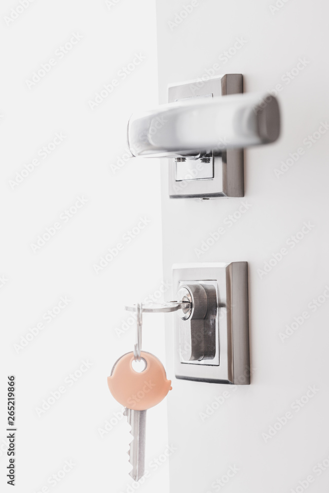 Open white door at home. Handle key close up. Open white door at home. Handle key close up.
