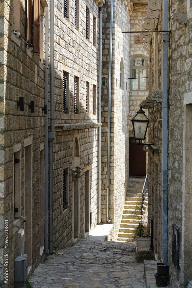 Breathtaking view of an empty narrow sunlit street on a small island in Adriatic