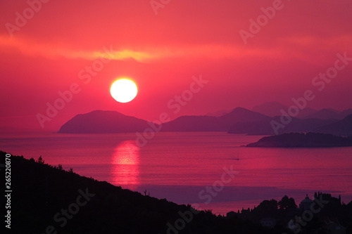 DRONE  Breathtaking shot of sun setting behind islands and calm sea in Dalmatia.