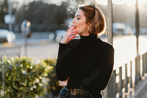 Pretty woman smoking on street photo