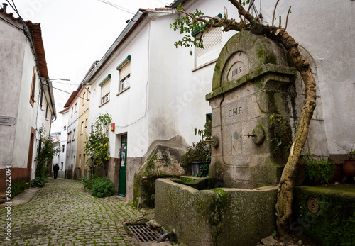 a cobbled street with an antique water fountain in Barroca Schist Village, Fundao, Portugal photo