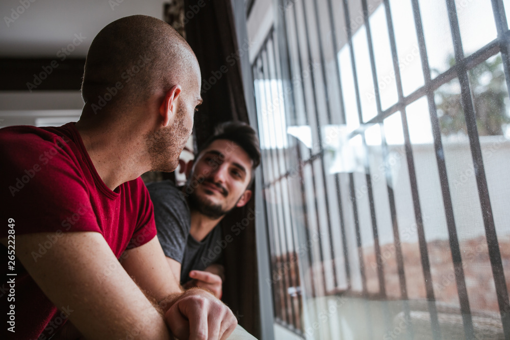 Gay couple looks fondly at the window Gay couple looks fondly at the window