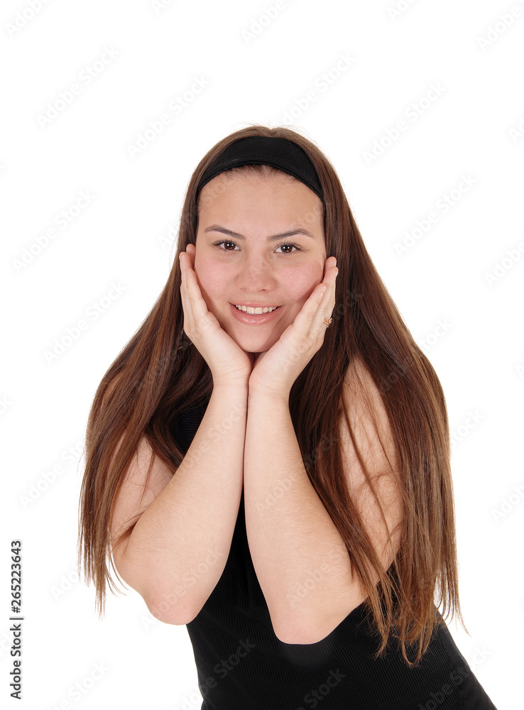 Pretty teen girl standing with booths hands on face Pretty teen girl standing with booths hands on face