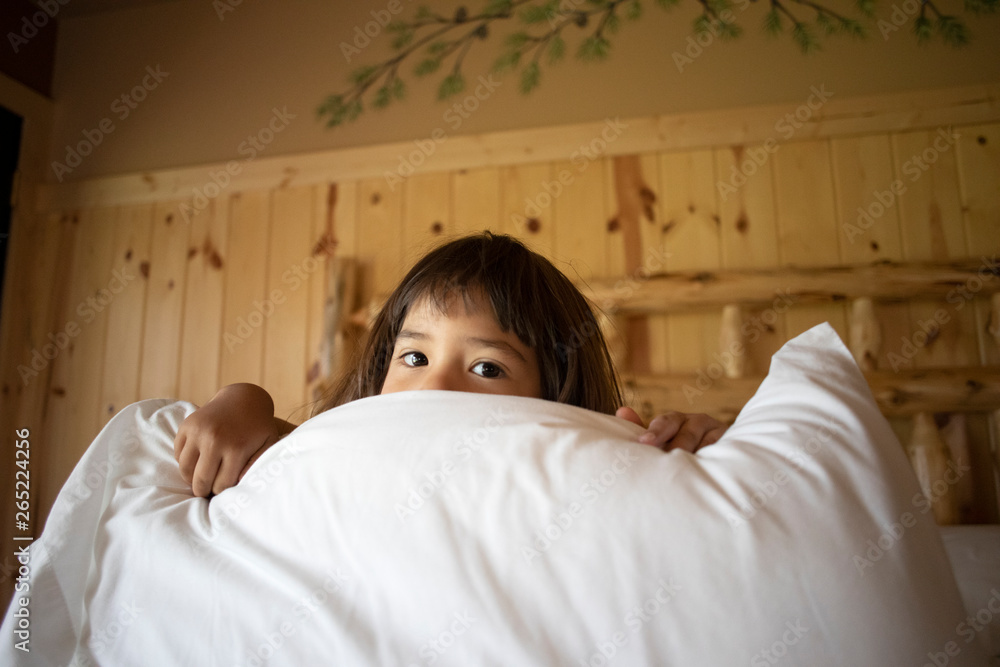 A toddler aged girl waking up from a nap inside of a house.