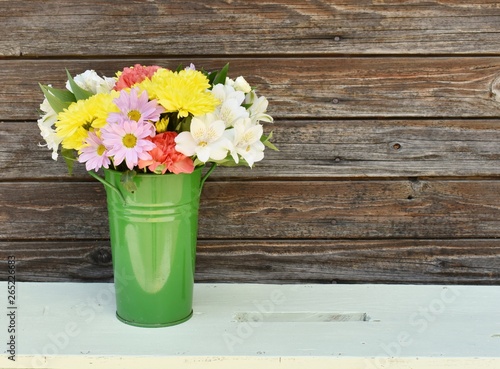 Bouquet of spring flowers on a light green bench