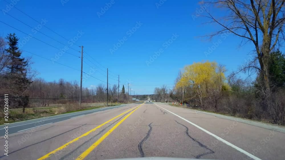 Driving Rural Countryside During Spring Day. Driver Point of View POV Along Beautiful Sunny Country Road. Driving Rural Countryside During Spring Day. Driver Point of View POV Along Beautiful Sunny Country Road.
