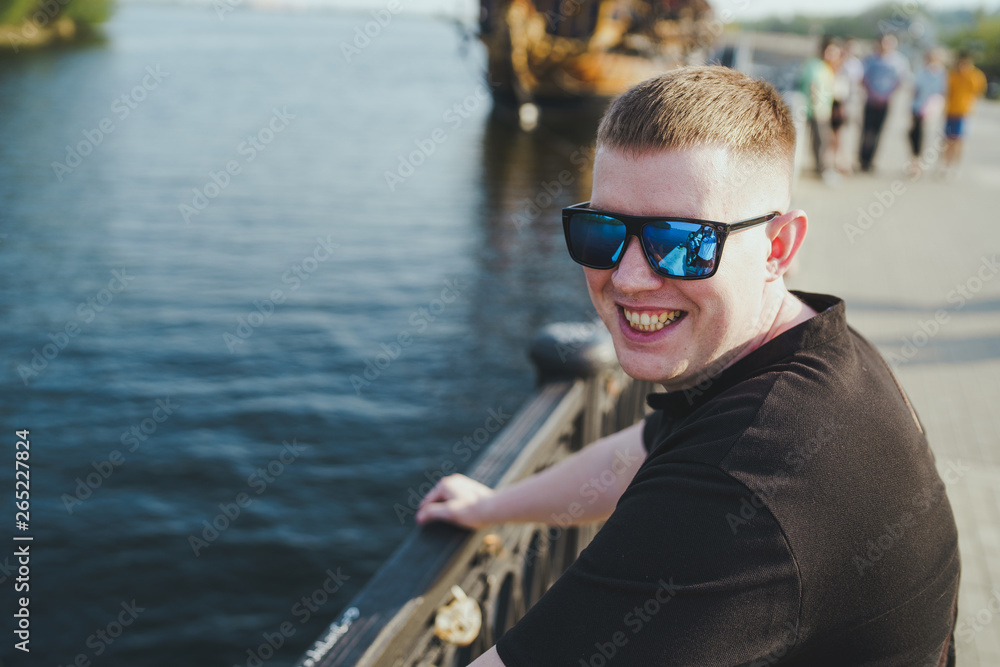 Man in sunglasses near river. Portrait male in sunglasses on sunny day Man in sunglasses near river. Portrait male in sunglasses on sunny day