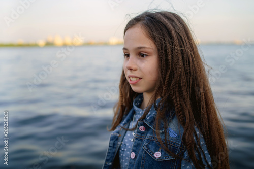 Teenage girl on the pier by the water.