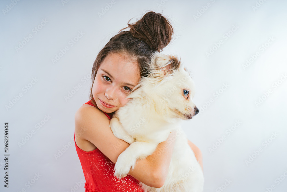 Beautiful young girl posing with dog on white background