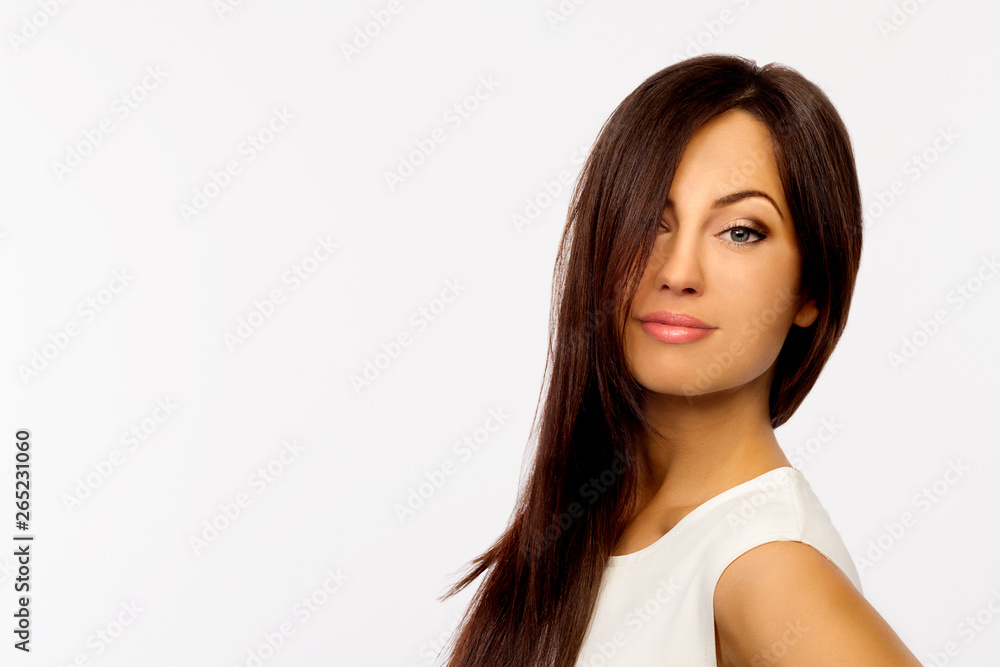 Portrait of beautiful young smiling woman with long brown hair on white background. Copy space Portrait of beautiful young smiling woman with long brown hair on white background. Copy space