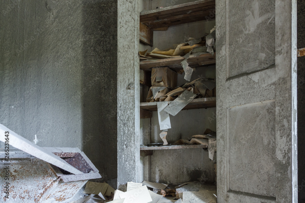 Obraz premium Random papers and books falling off shelves in soot covered abandoned factory